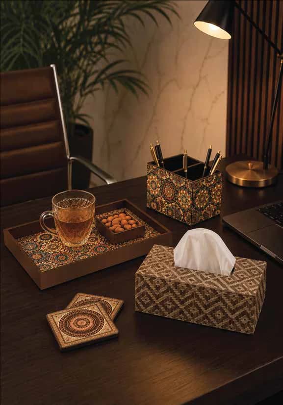 A printed tissue box, pen stand, tray and coasters on a desk